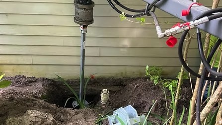 Helical pile installed beside a house foundation